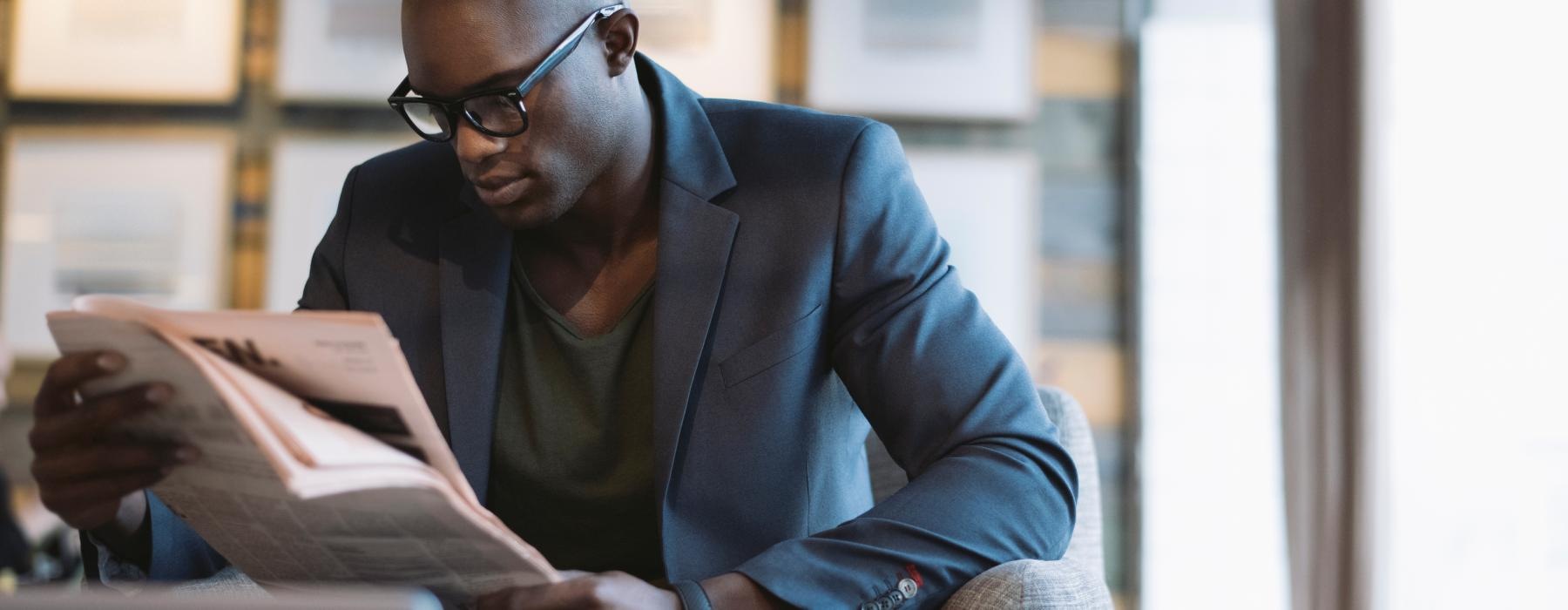 a man sitting on a chair reading a book