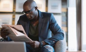 Black Man Wear a Reading Eye Glasses While Reading an Articles in Magazine
